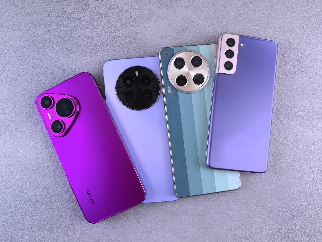 Array of colorful modern smartphones displayed on a grey surface.